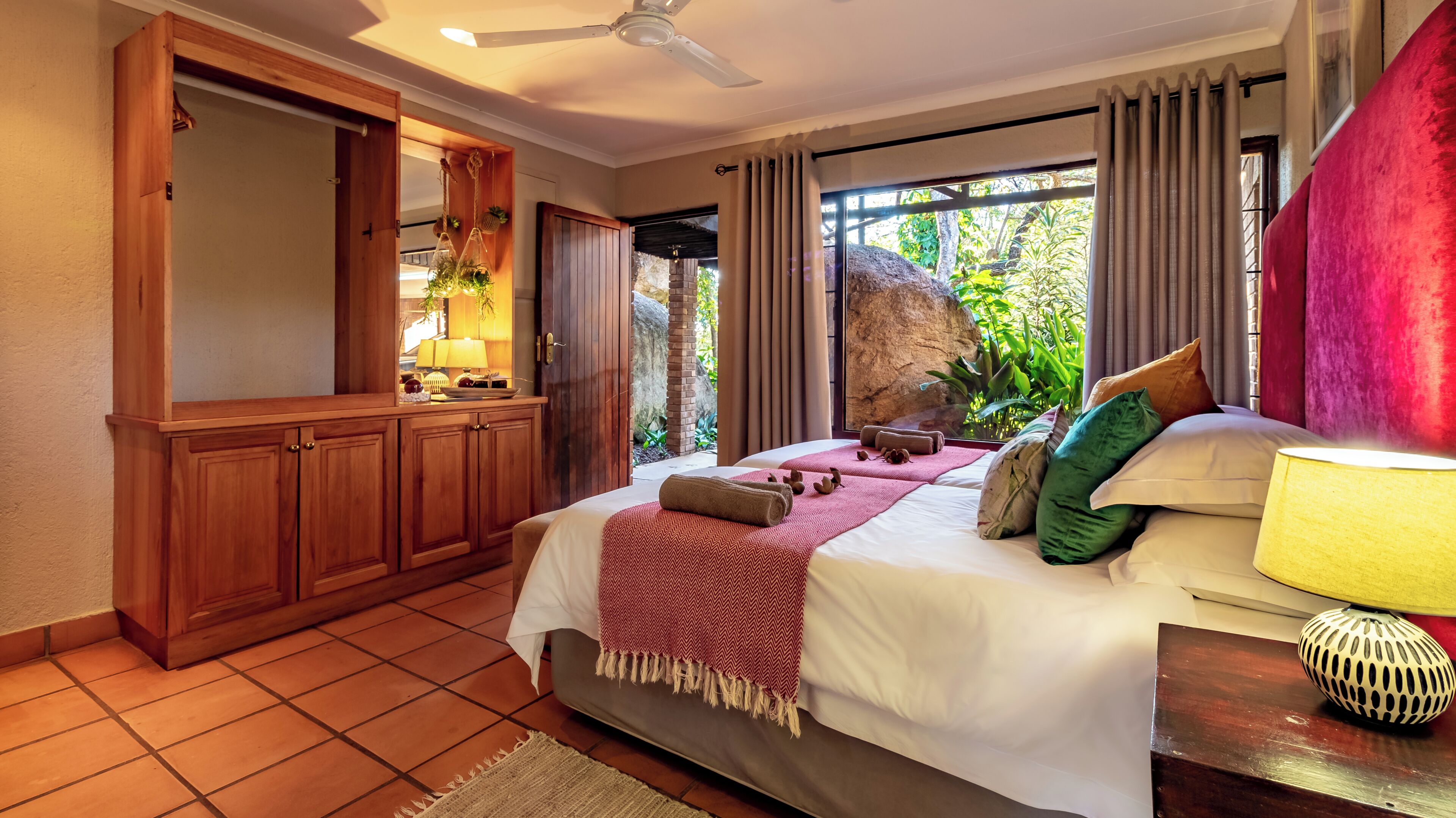 Une chambre à coucher avec un lit, une table de chevet et une vue sur la verdure.
