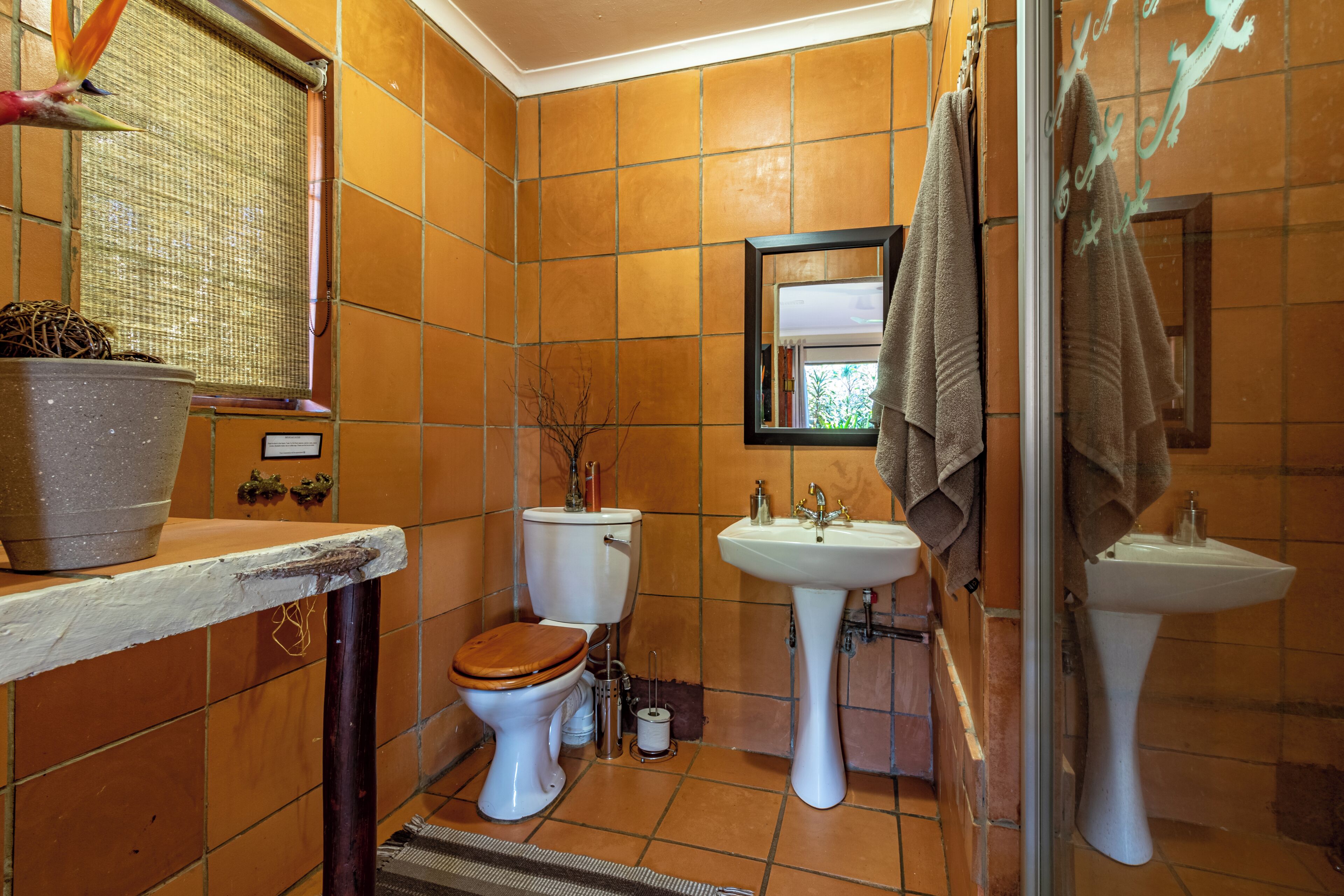 A bathroom with a toilet, sink, and shower.