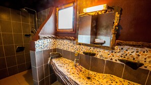 A bathroom with a mosaic tile backsplash, a wooden vanity, a mirror, and a shower area. - La Baie des Tortues Luth (Point Denis)
