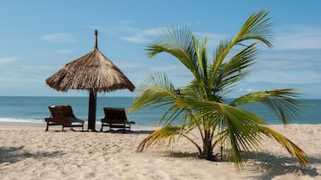 På stranden, vit sandstrand, strandhanddukar och vattenskidåkning