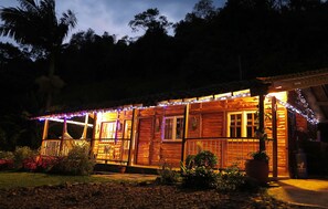Cozy cabin surrounded by lush gardens and trees, offering a peaceful retreat.