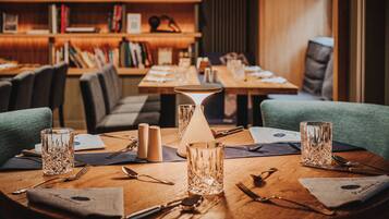 Una mesa de comedor con una lámpara, saleros y pimenteros, y una carta.