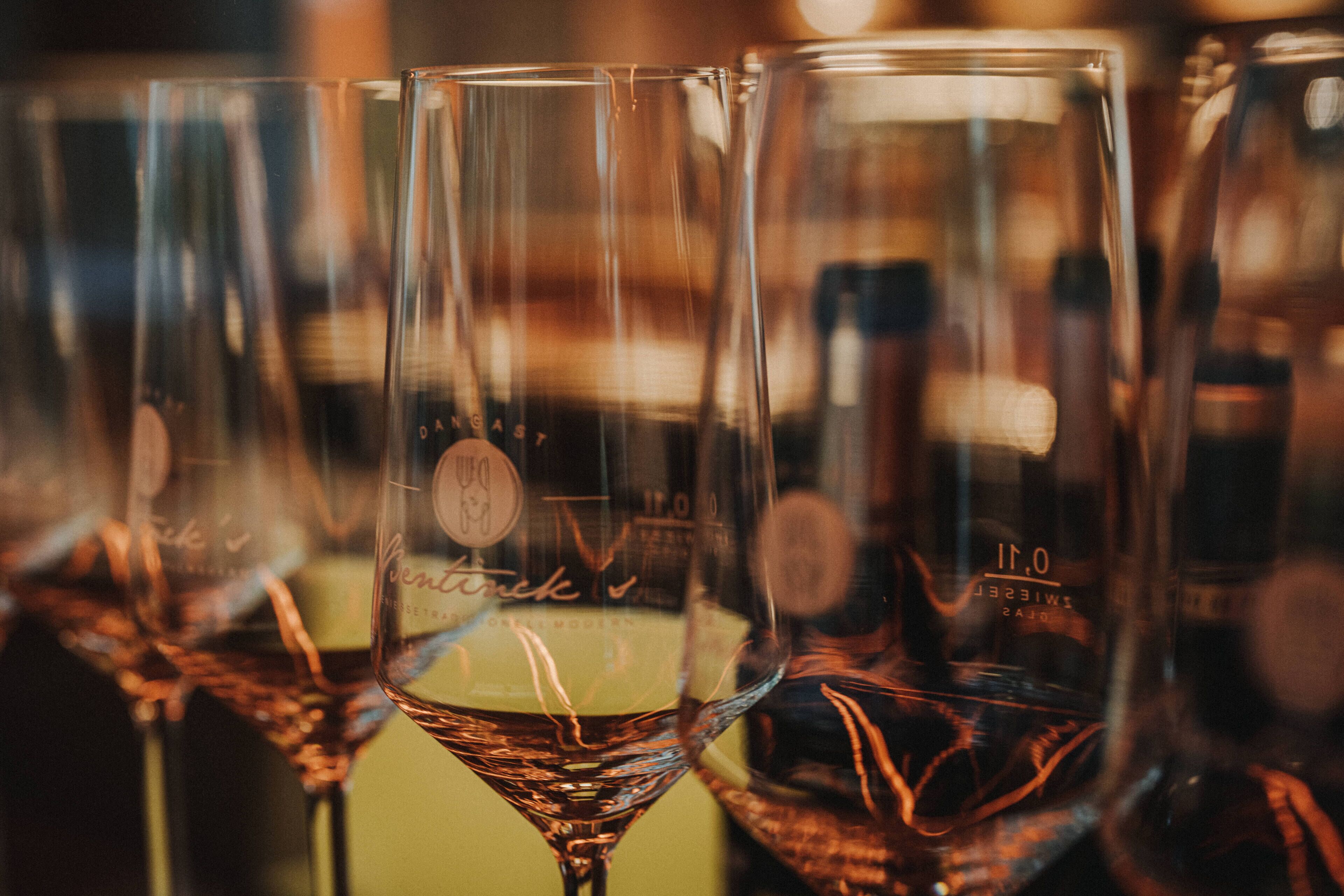A row of empty wine glasses with visible branding on the stems.