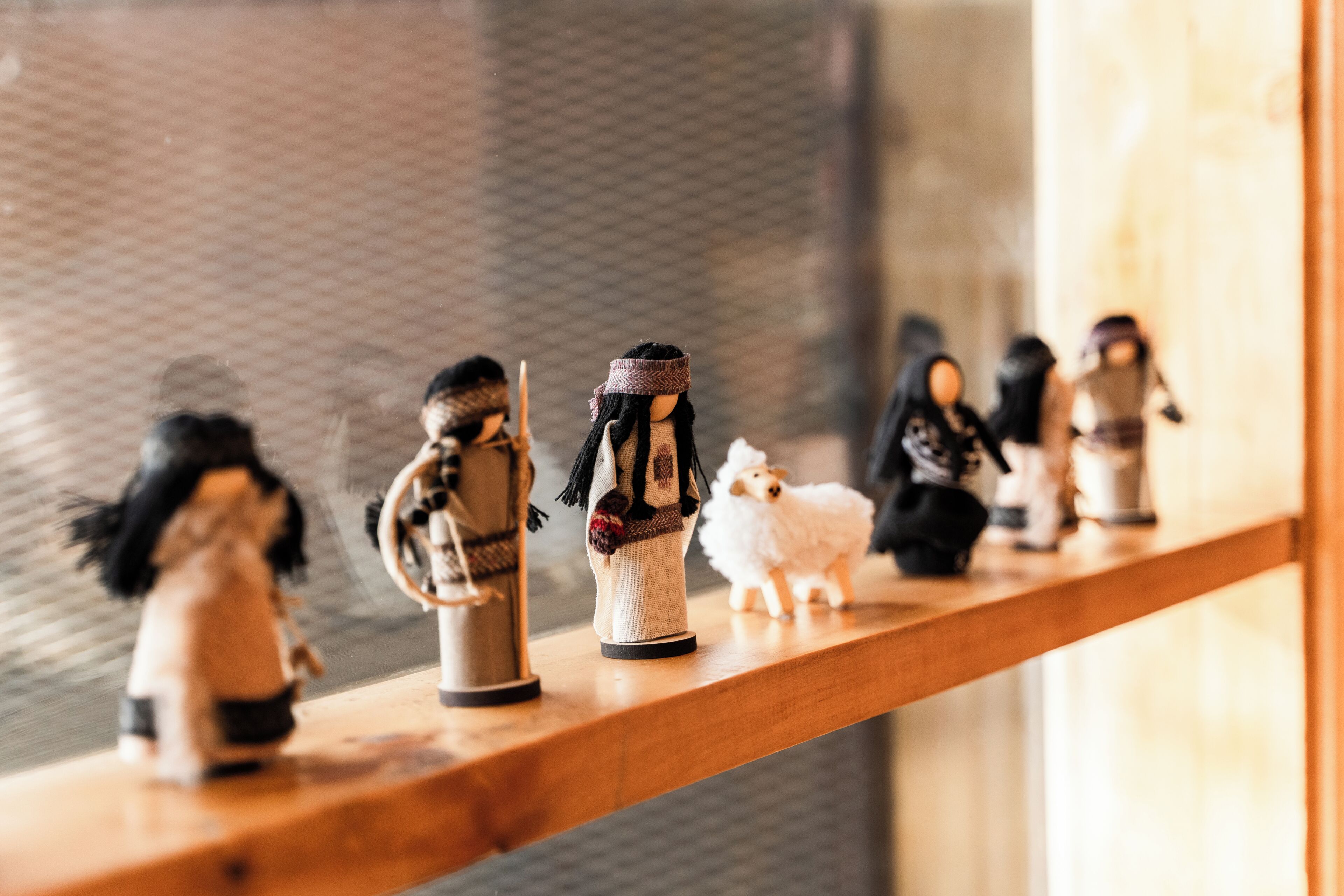Une étagère avec de petites figurines, dont un mouton blanc.