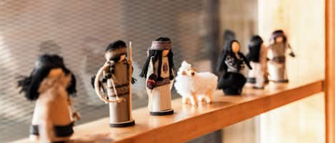Une étagère avec de petites figurines, dont un mouton blanc.