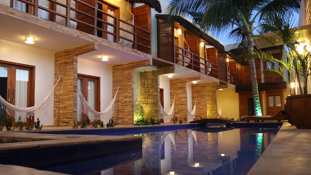Zona de piscina con vista despejada al exterior de un edificio, que incluye balcones de madera y fachada de piedra.