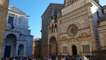 Un bâtiment historique aux détails architecturaux complexes, devant lequel se trouve une foule de personnes.