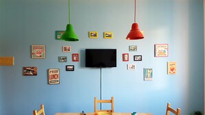 A dining area with a wooden table, chairs, and a television mounted on the wall. - Retro Apartment (Bergamo)