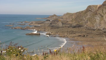 A coastal landscape with rocky cliffs and a beach.