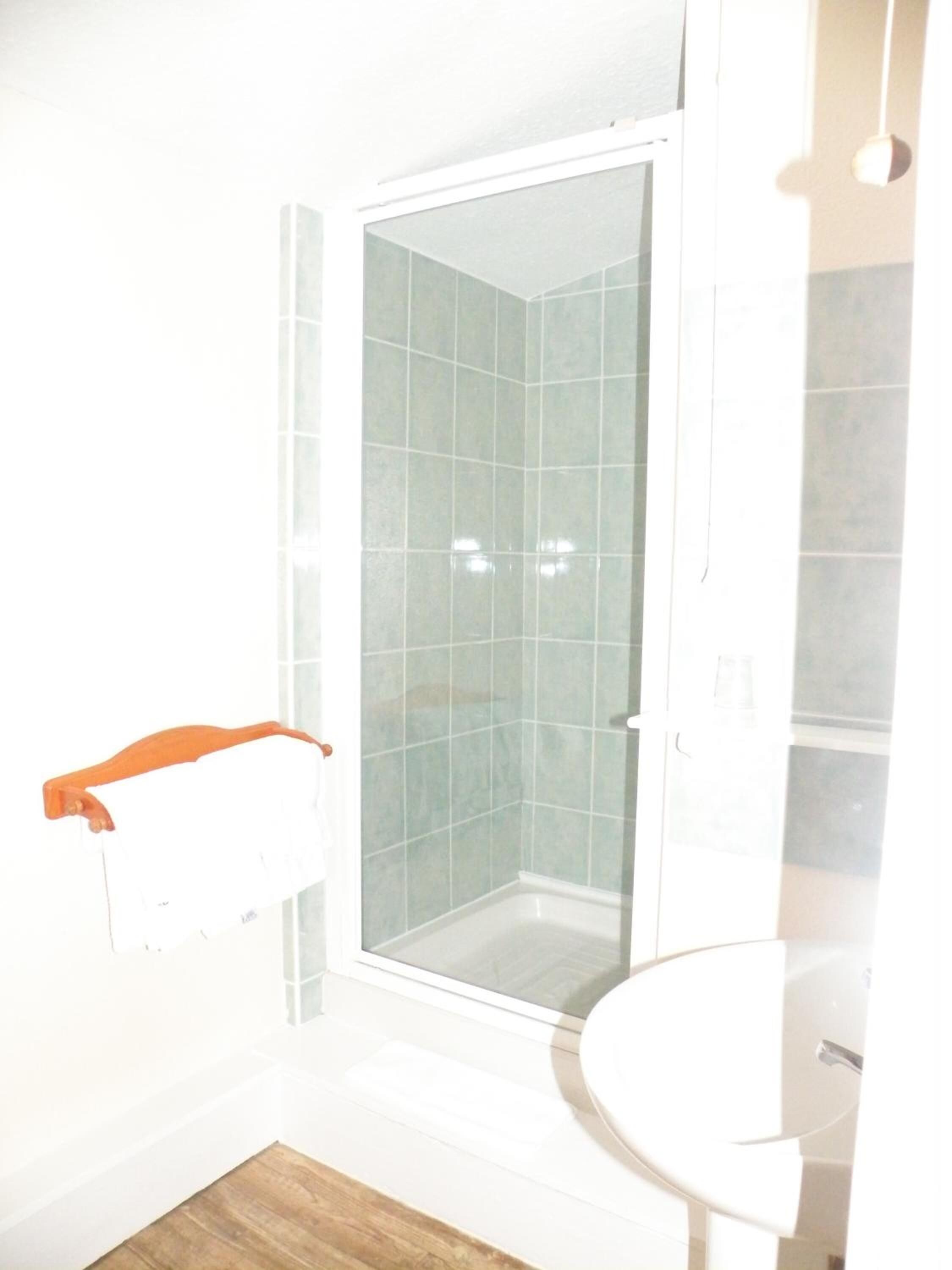 Une salle de bain avec une douche, des toilettes et un lavabo.