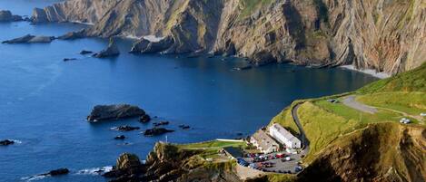 A coastal cliffside with a parking area and buildings.
