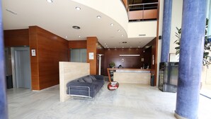 Un moderno vestíbulo de hotel con una recepción, un sofá y una mesita de café.