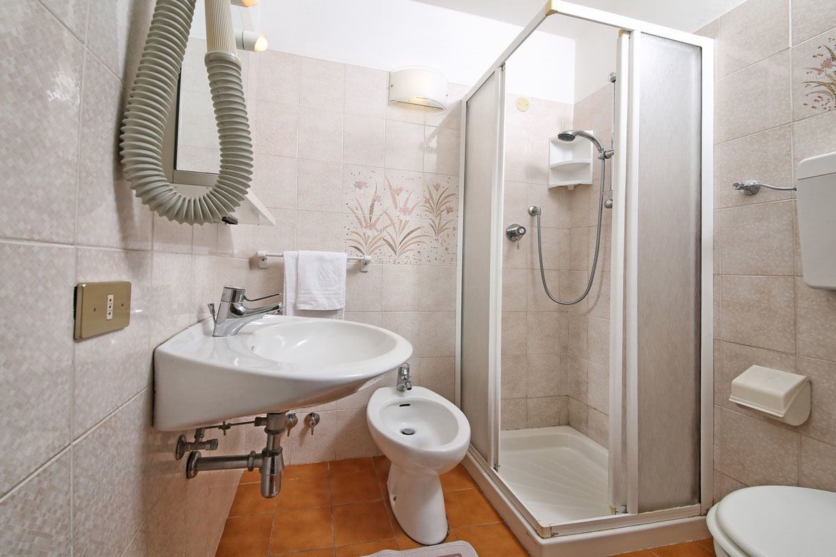 Ein modernes Badezimmer mit Dusche, Waschbecken, Bidet und Toilette.