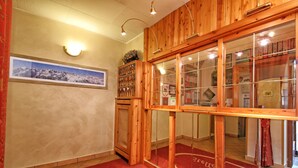 A wooden interior with a red carpet, a wall-mounted light fixture, and a framed picture. - Hotel Stella Alpina (Fai della Paganella)