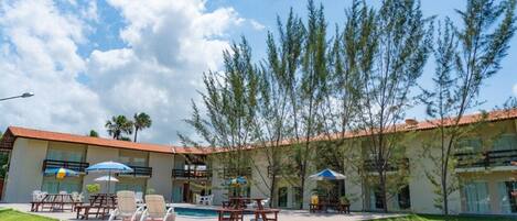 Un hotel con piscina, zona de estar al aire libre y jardín.