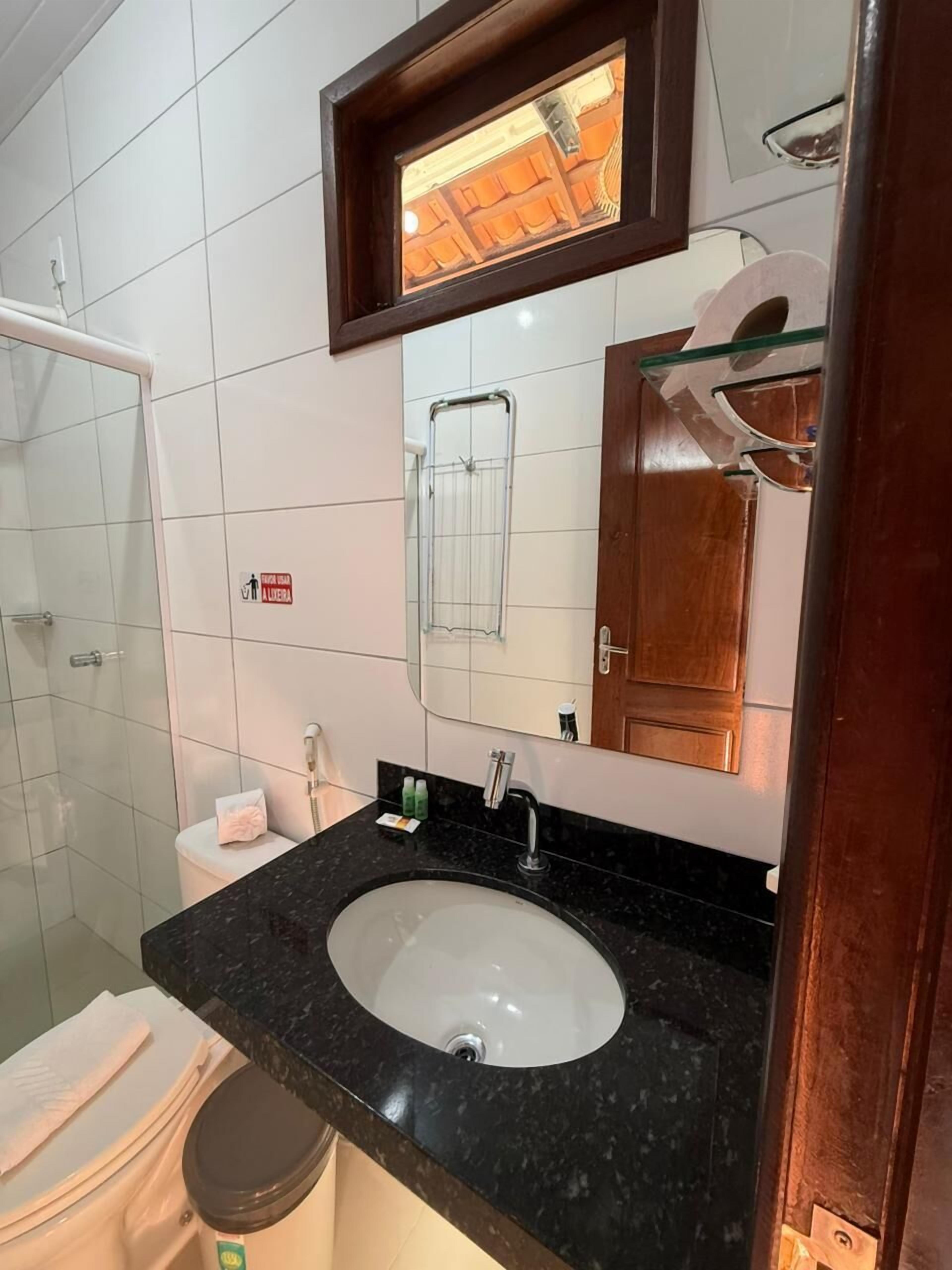 Ein Badezimmer mit Waschbecken, Spiegel und Dusche.