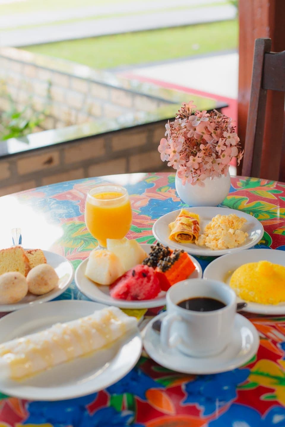 A table with breakfast items including bread, fruit, and a cup of coffee.