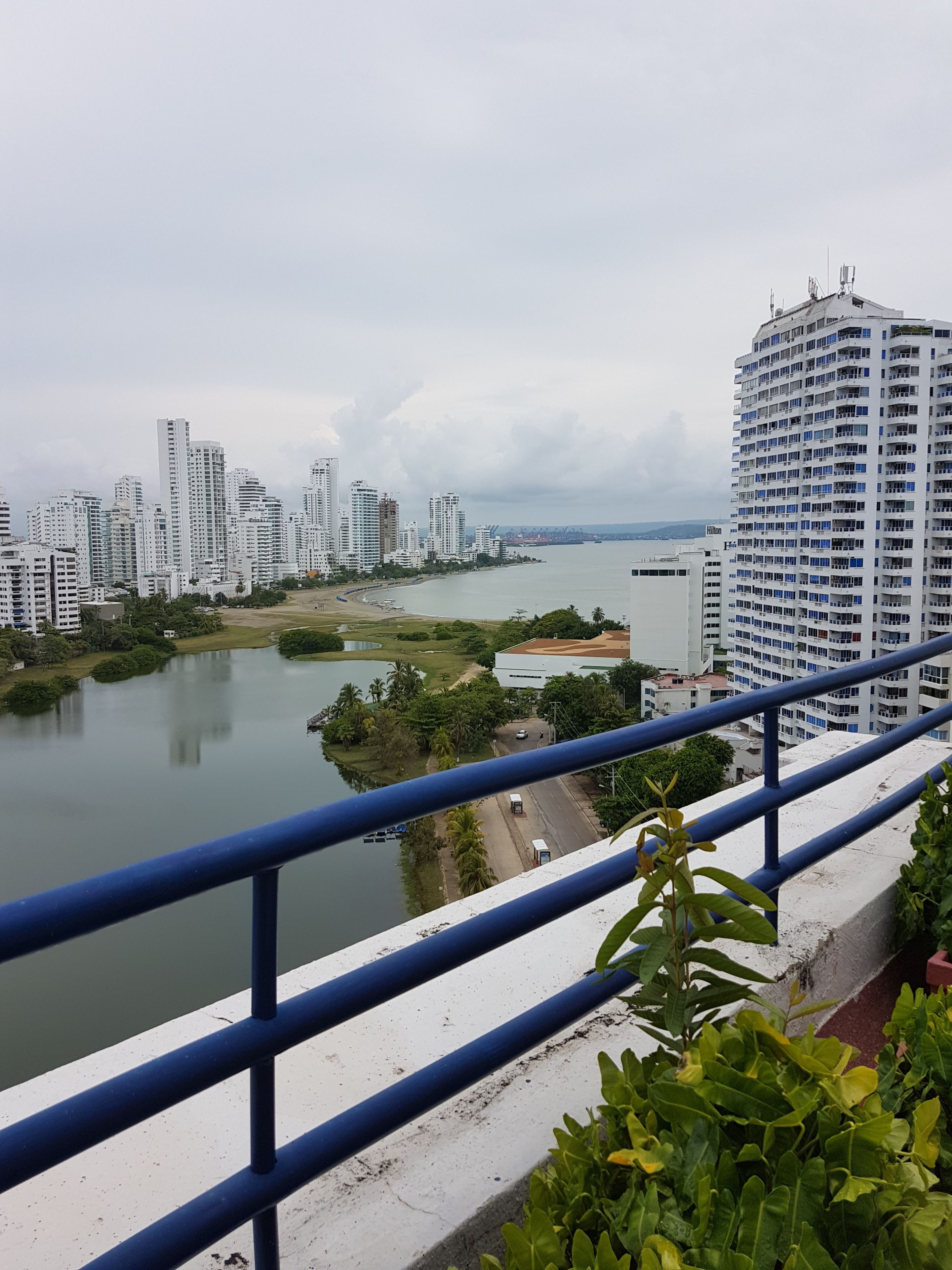 A high-rise building with a view of a river and other buildings.