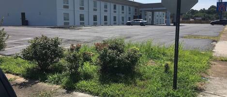 A parking lot with a stop sign and a building in the background.