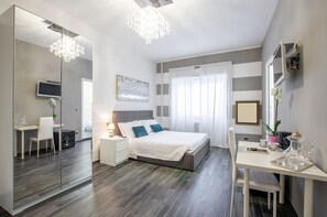 A modern bedroom with a large bed, bedside tables, a desk, and a mirror. - Trastevere Sweet House (Rome)