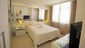 A hotel room with a large bed, a television, a desk with a computer, and a large mirror. - Rio Spot Begossi (Rio de Janeiro)
