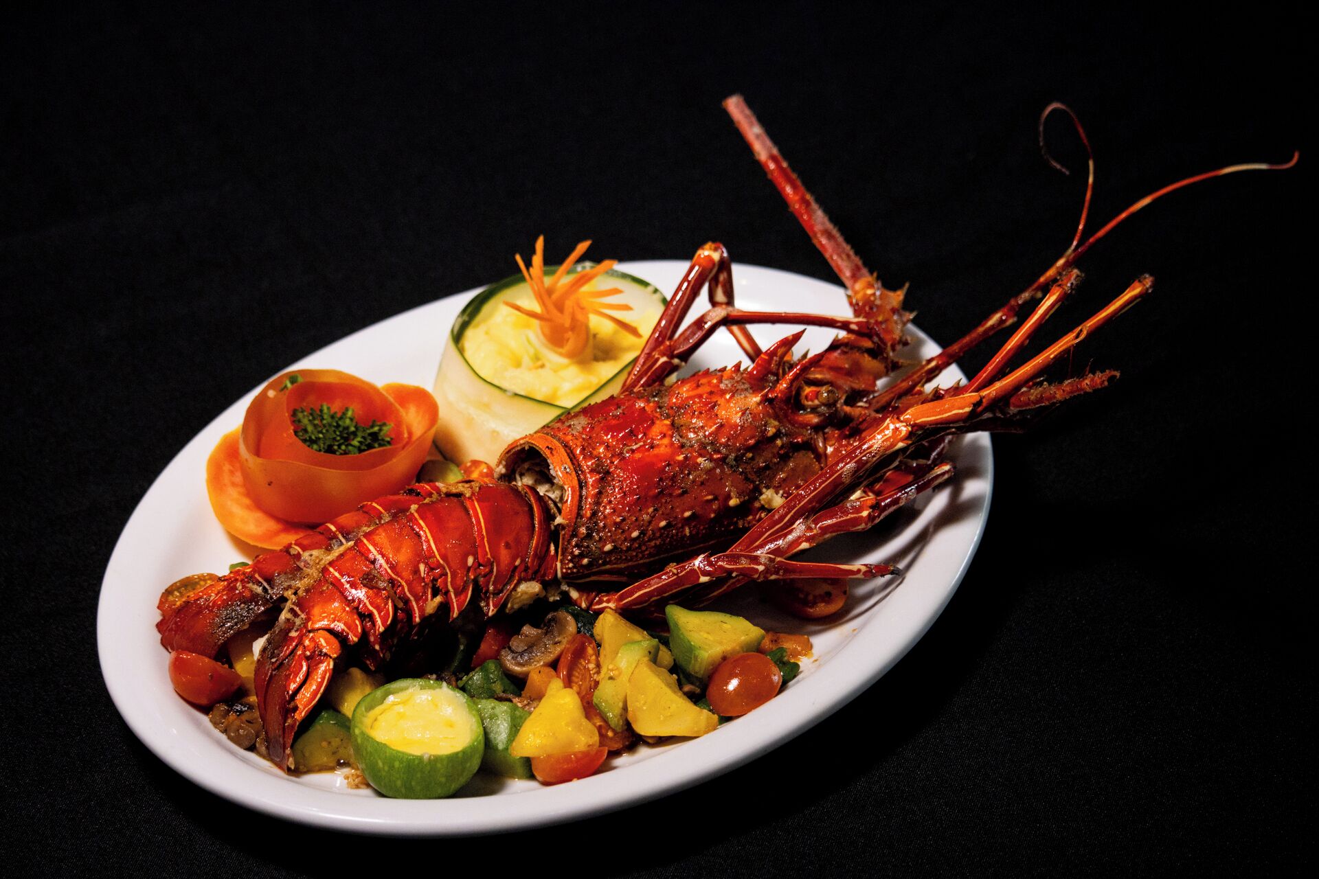 A lobster dish with vegetables on a plate.