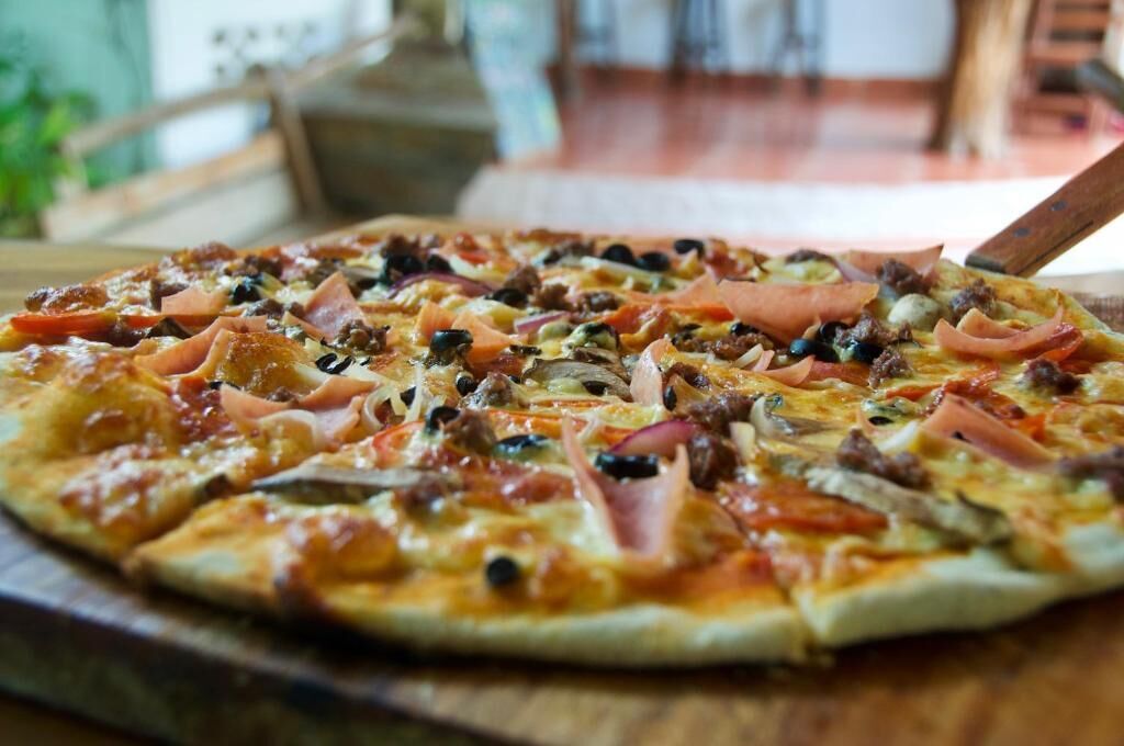 A pizza with various toppings on a wooden board.