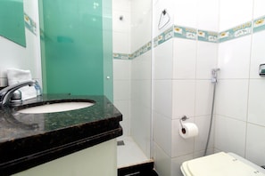 Une salle de bain avec un lavabo, des toilettes et une douche.