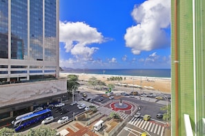 Une vue urbaine comprenant une plage, un rond-point et une ligne de tramway.