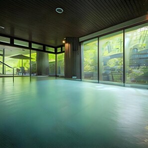 A spacious indoor area with large windows, a wooden ceiling, and a view of greenery outside.