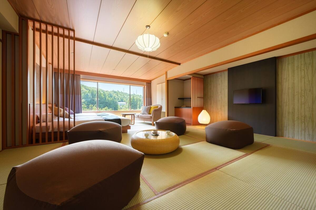 A traditional Japanese-style room with tatami flooring, a low ceiling, and a view of the outdoors.