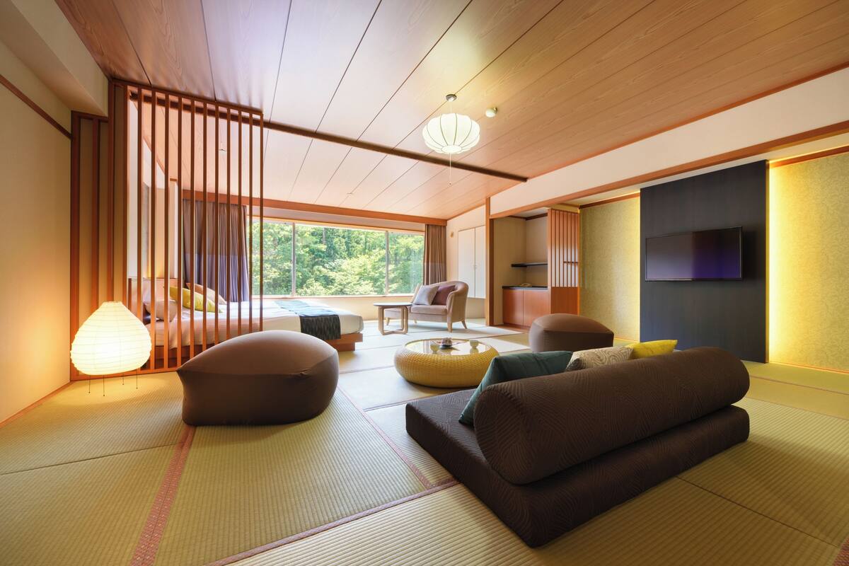 A traditional Japanese-style room with tatami flooring, a low wooden ceiling, and a sliding door.