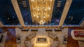 A spacious lounge area with a central seating arrangement, large windows, and a decorative chandelier. - Akiu Grand Hotel (Sendai)