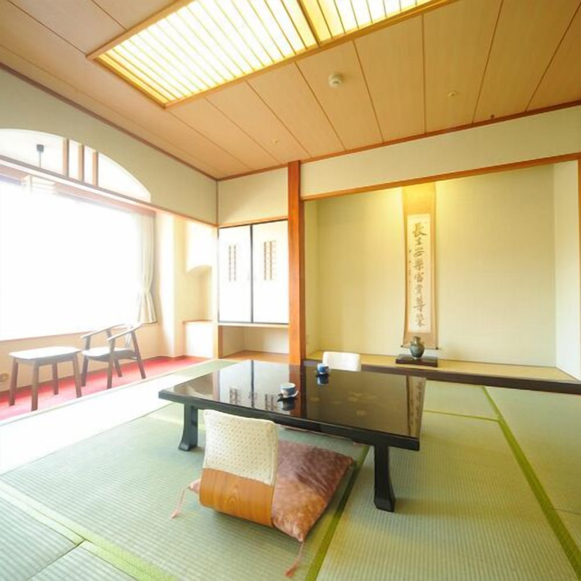 A traditional Japanese room with tatami flooring, a low table, and sliding doors.
