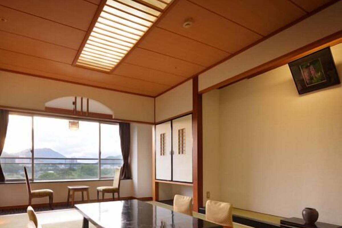 A traditional Japanese-style meeting room with tatami flooring, a low table, and chairs.