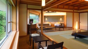 A traditional Japanese-style room with tatami flooring, a low table, and chairs. - Akiu Grand Hotel (Sendai)