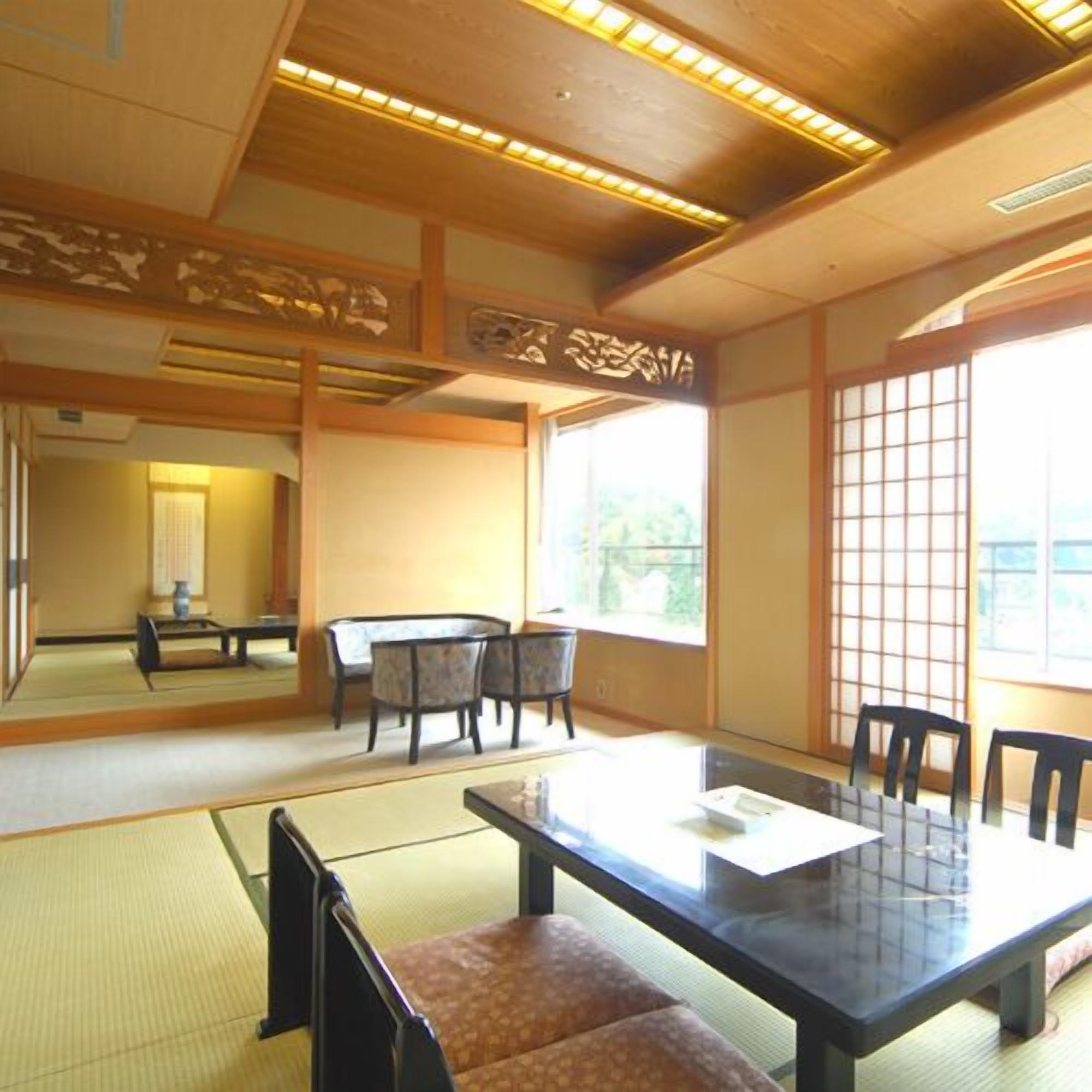Ein traditioneller japanischer Raum mit Tatami-Bodenbelag, einem niedrigen Tisch und Stühlen.
