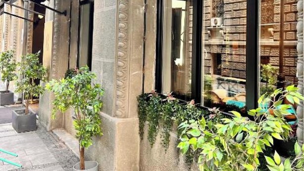 The exterior of the Capital Hotel with a modern facade, large windows, and potted plants along the sidewalk. - Hotel Capital (Belgrade)