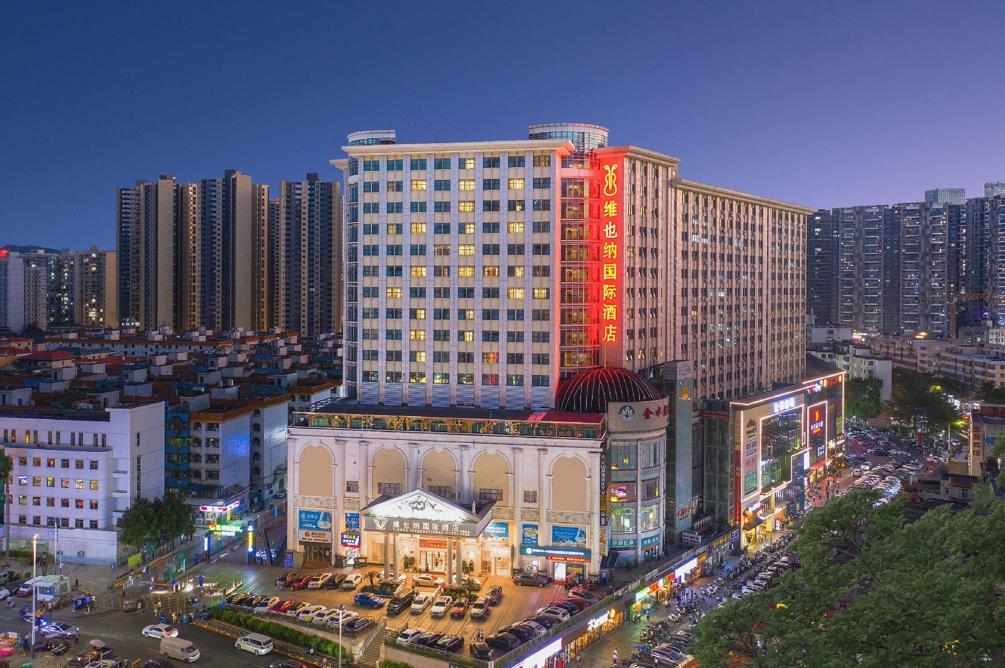 A high-rise hotel with multiple floors, a large entrance, and a parking area.