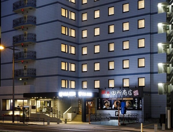 A multi-story hotel with a modern facade, balconies, and a ground-level entrance with a visible sign. - Via Inn Shimonoseki (Shimonoseki)