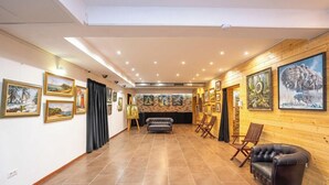 A hallway with artwork on the walls, a sofa, and a leather chair.