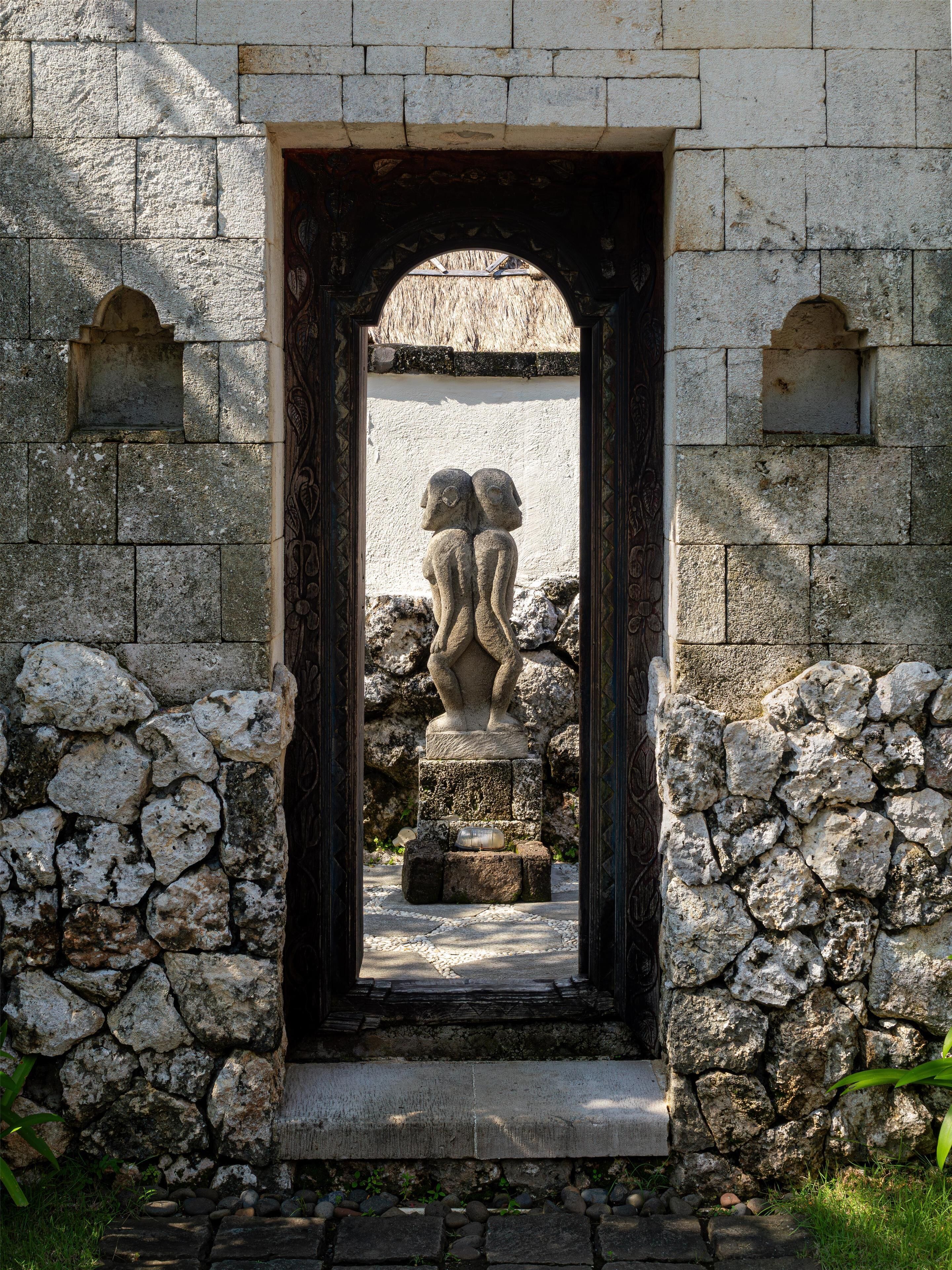 A stone doorway with a statue of two figures in a niche.