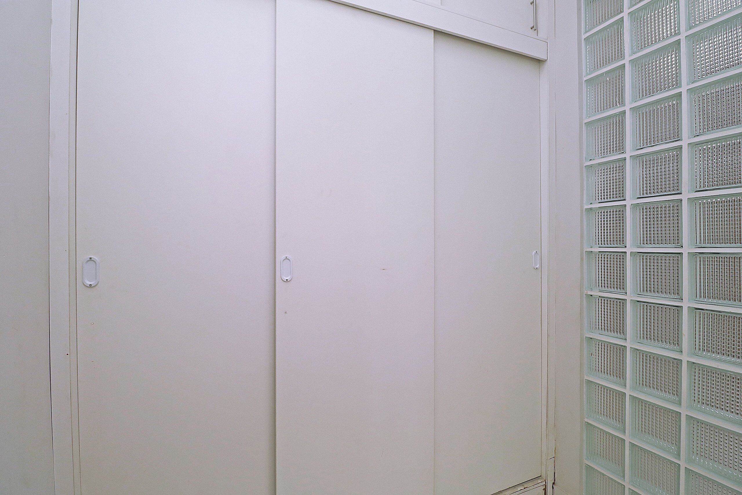 A white door with two handles and a window with a grid pattern.