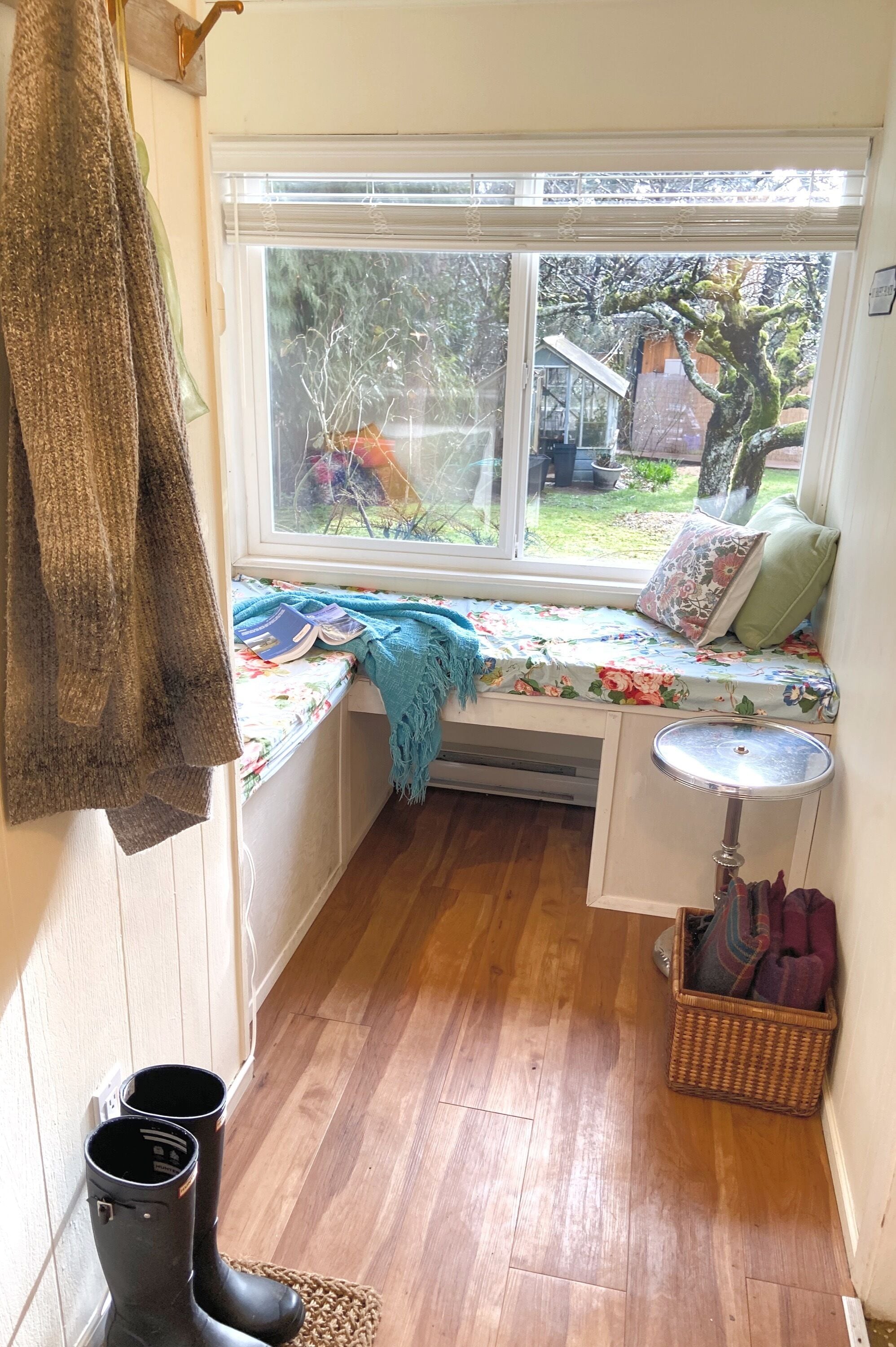 A cozy room with a window seat, a small table, and a basket.