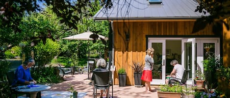Eine Terrassenanlage im Freien mit Holzboden, Topfpflanzen und Gartenmöbeln.
