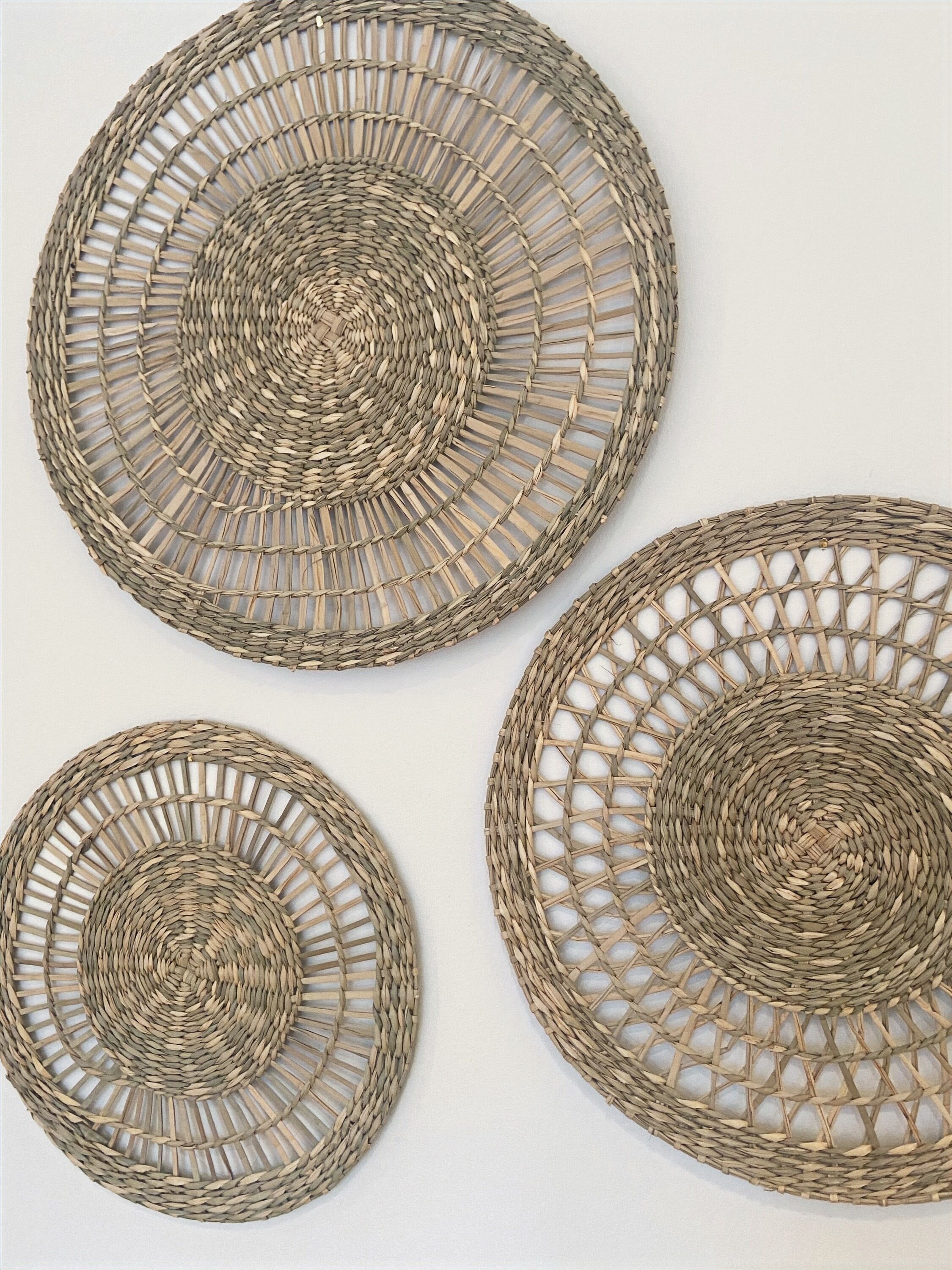 Three circular woven placemats.