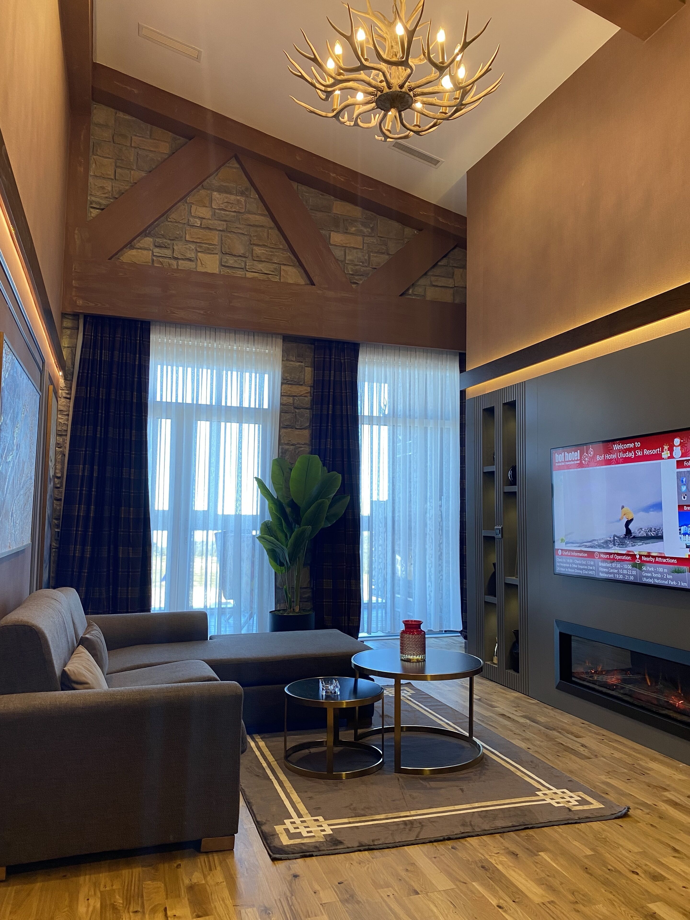 A living room with a sofa, a coffee table, a television, and a fireplace.