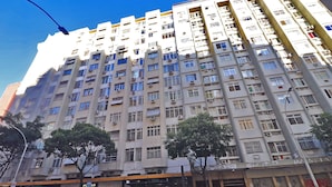 A multi-story residential building with balconies, air conditioning units, and a storefront at the ground level. - Rio Spot Apartment D038 (Rio de Janeiro)