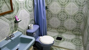 A bathroom with a toilet, sink, and shower curtain. - Hotel Jordan (Coatzacoalcos)