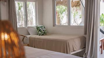 A bedroom with two beds, a ceiling fan, an air conditioning unit, and windows with curtains.